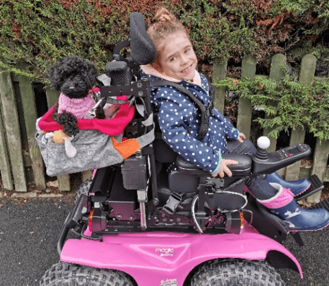 a girl sitting on a pink electric vehicle